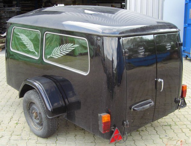 Bestattungsanhänger mit schwarzer Lackierung und Palmwedel-Motiv in den Fenstern